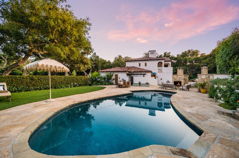 A spacious residence with a generous pool in the foreground